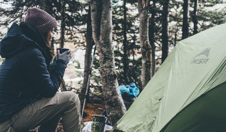 Camping avec femme devant une tente